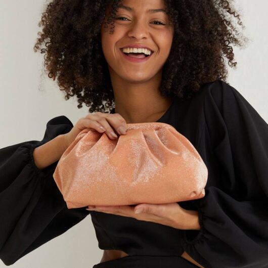 Belissh Women's Shimmery Pouch Bag With Detachable Crossbody Strap in Pale Orange